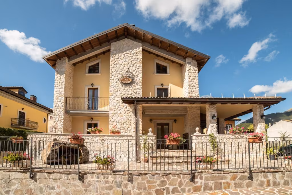 La facciata dell'albergo con la recinzione e il parcheggio
