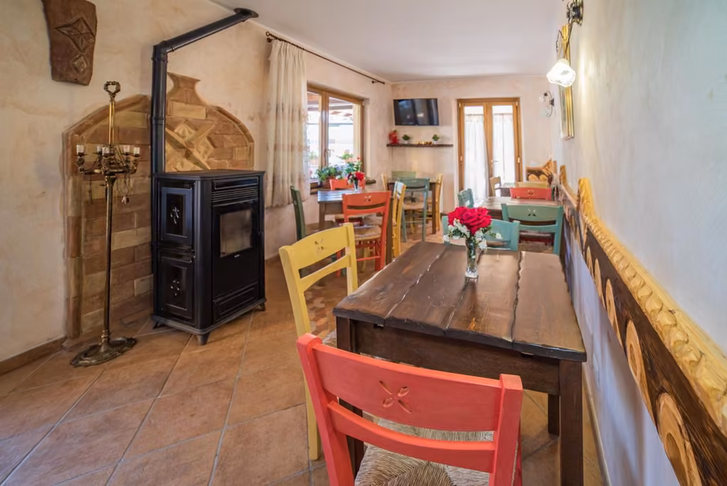 La sala da pranzo dell'albergo con il tavolo e la stufa a legna